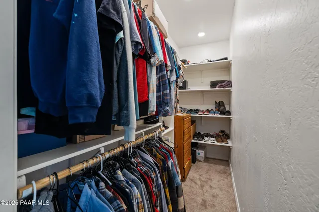 a view of walk in closet with clothes and shoes