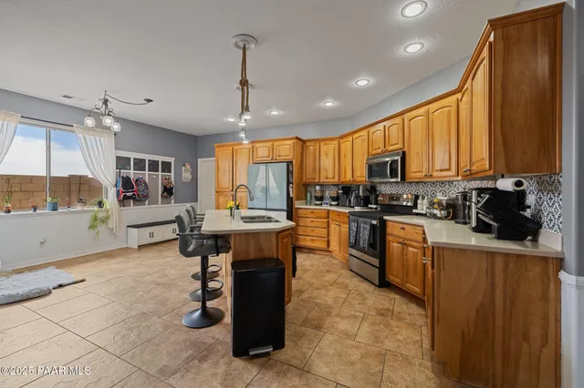 a kitchen with granite countertop a sink a counter top space and stainless steel appliances