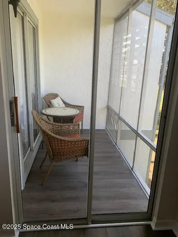 a living room with furniture a flat screen tv and kitchen view