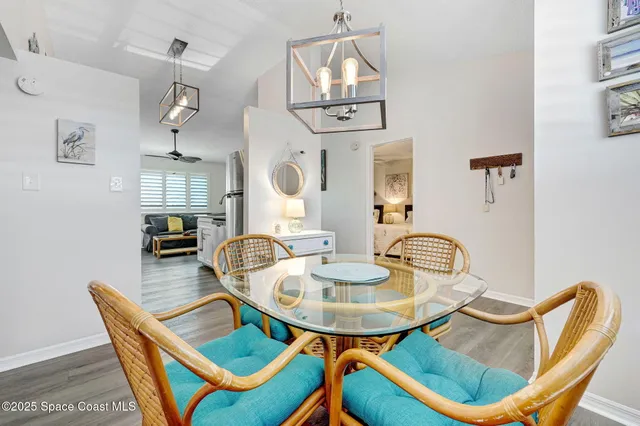 a dining room with furniture a chandelier and wooden floor