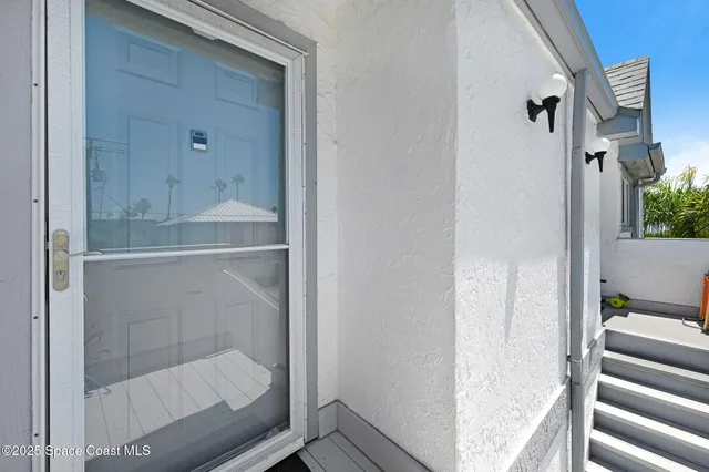 a view of a white house with a yard and potted plants