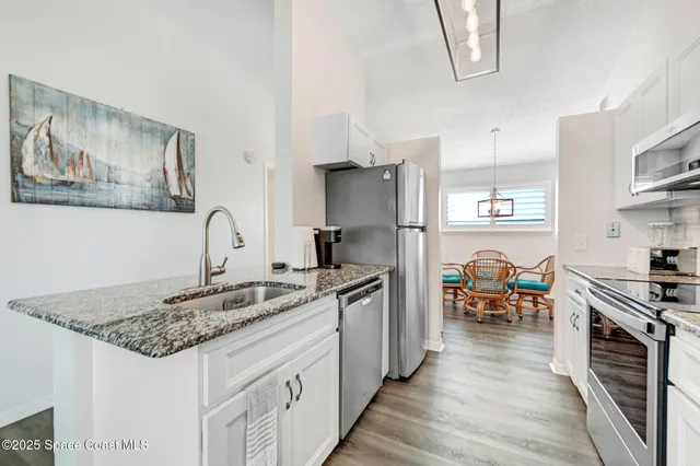 a kitchen with stainless steel appliances granite countertop a refrigerator a stove top oven a sink and dishwasher