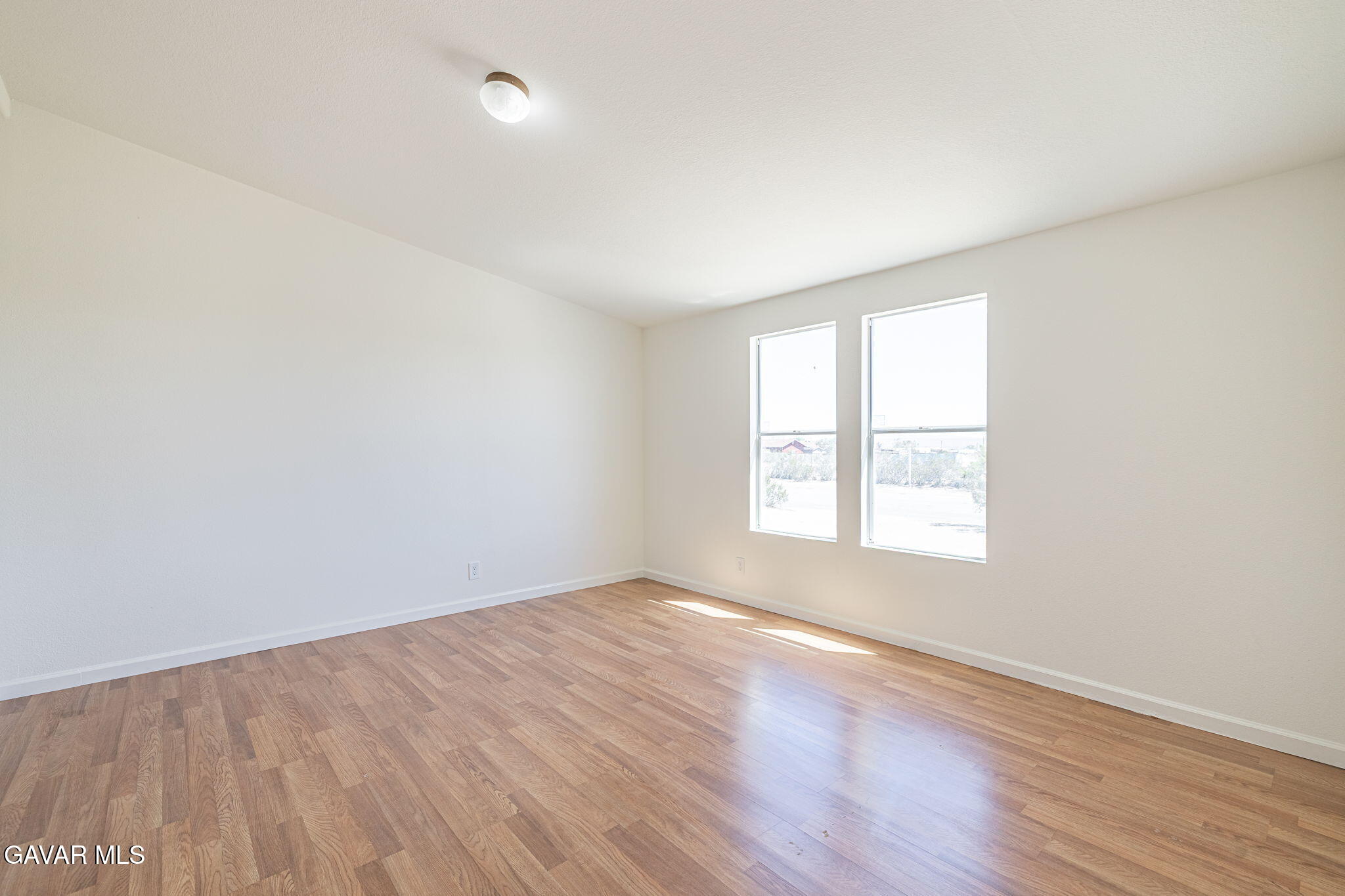 26321 Olanche Street Mojave, CA 93501 - Photo 17 of 40 an empty room with wooden floor and windows