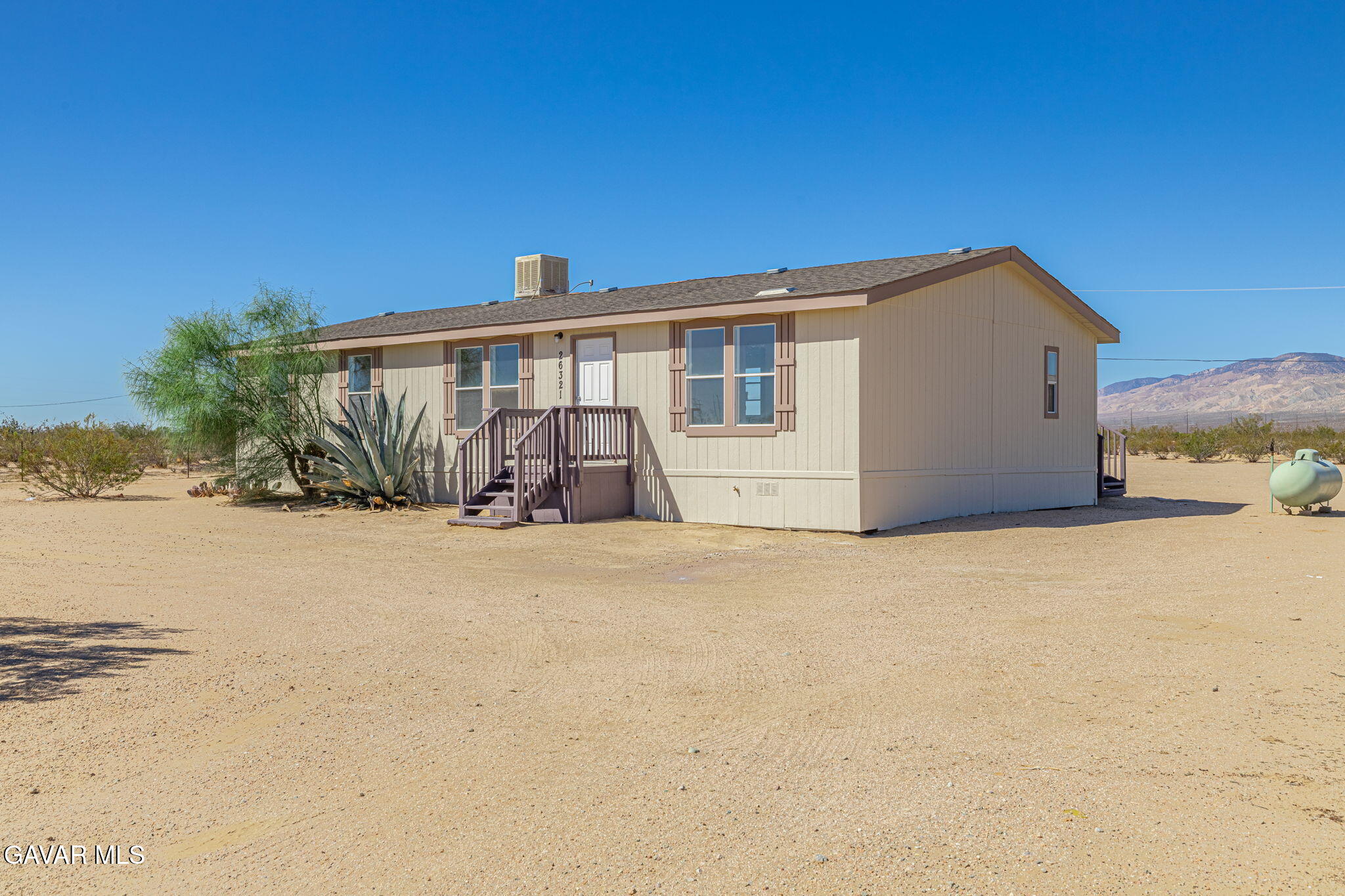 26321 Olanche Street Mojave, CA 93501 - Photo 2 of 40 a front view of house with yard and trees in the background
