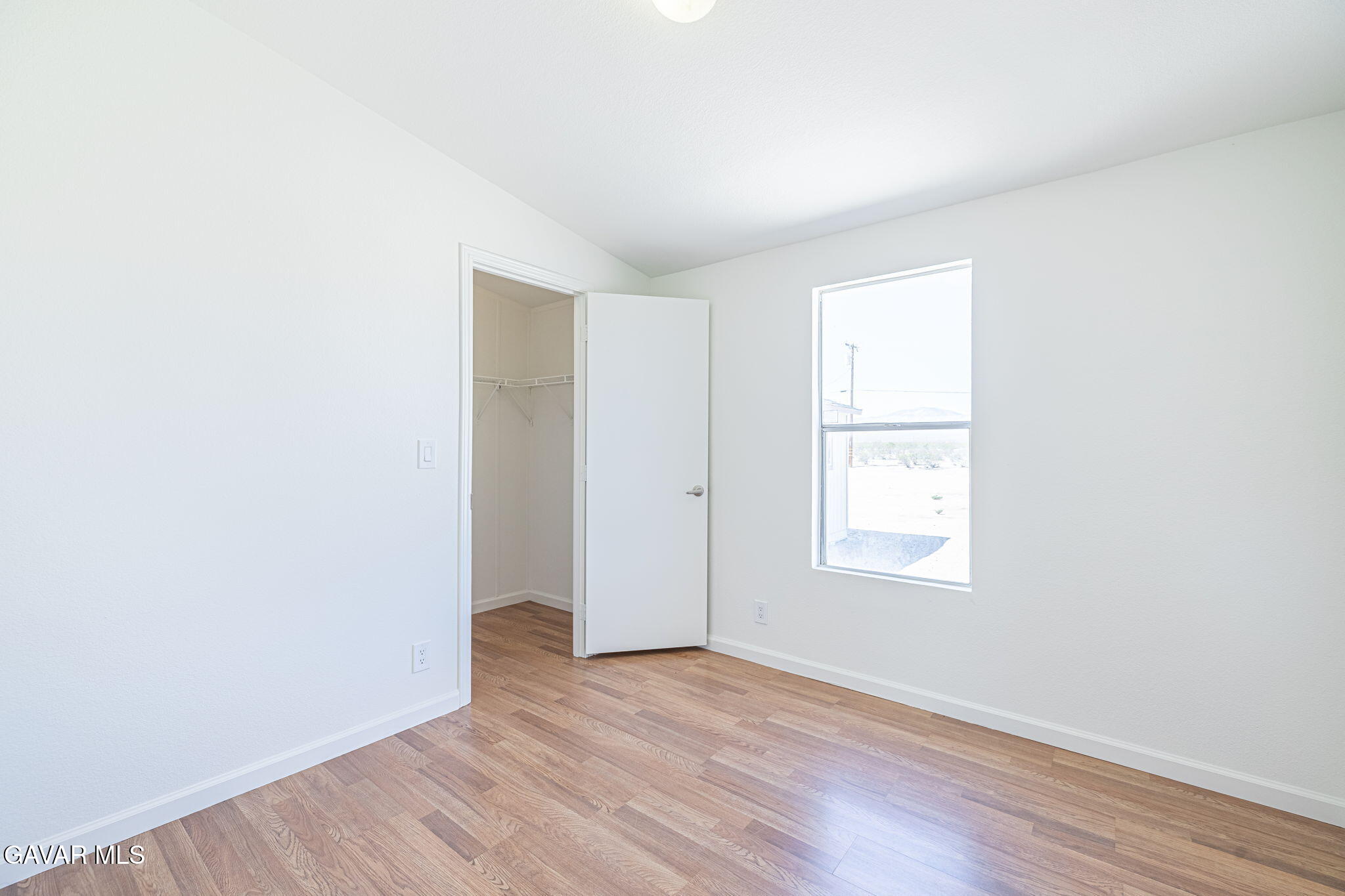 26321 Olanche Street Mojave, CA 93501 - Photo 23 of 40 an empty room with wooden floor and windows