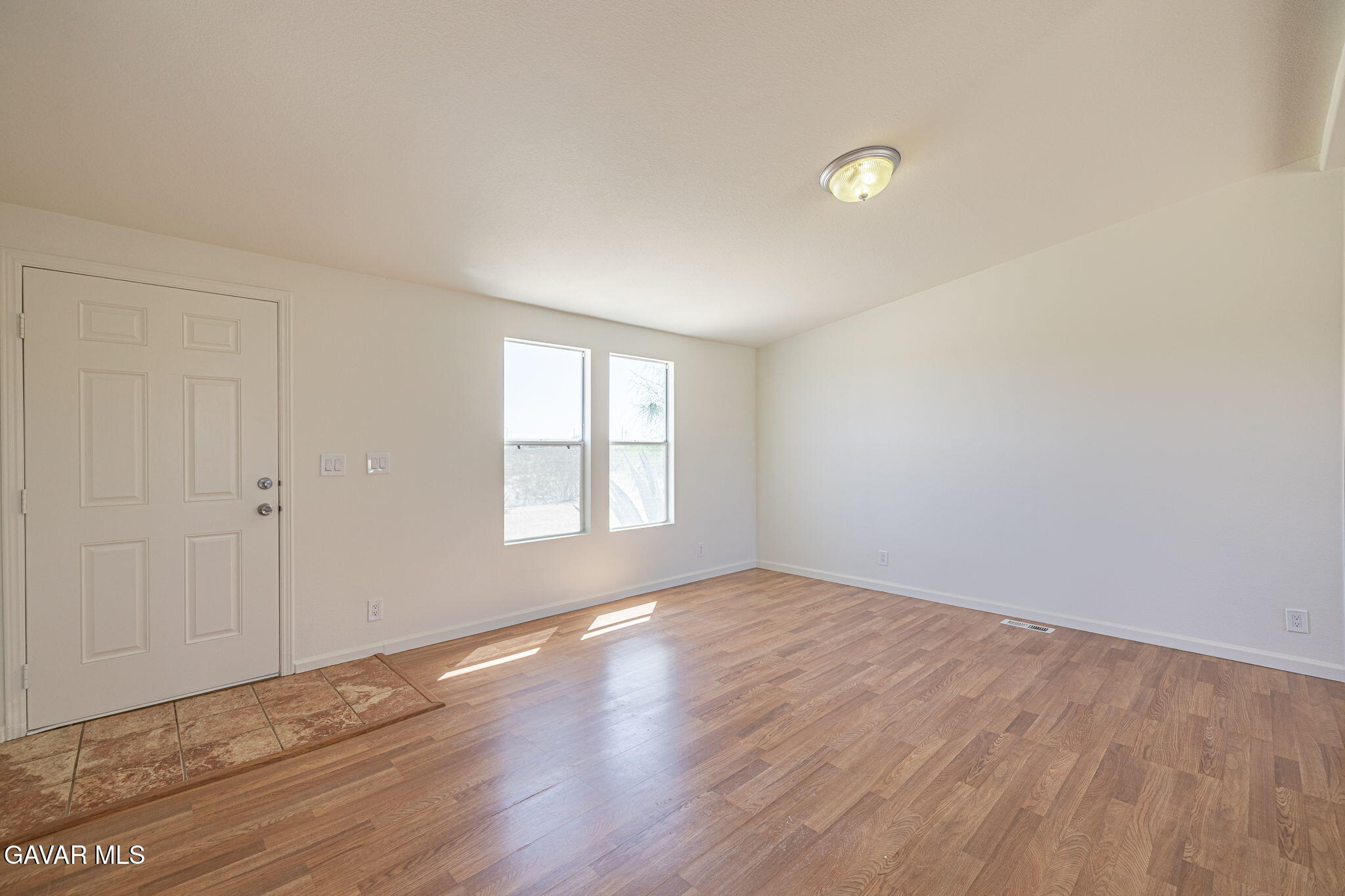 26321 Olanche Street Mojave, CA 93501 - Photo 7 of 40 a view of an empty room with wooden floor and a window