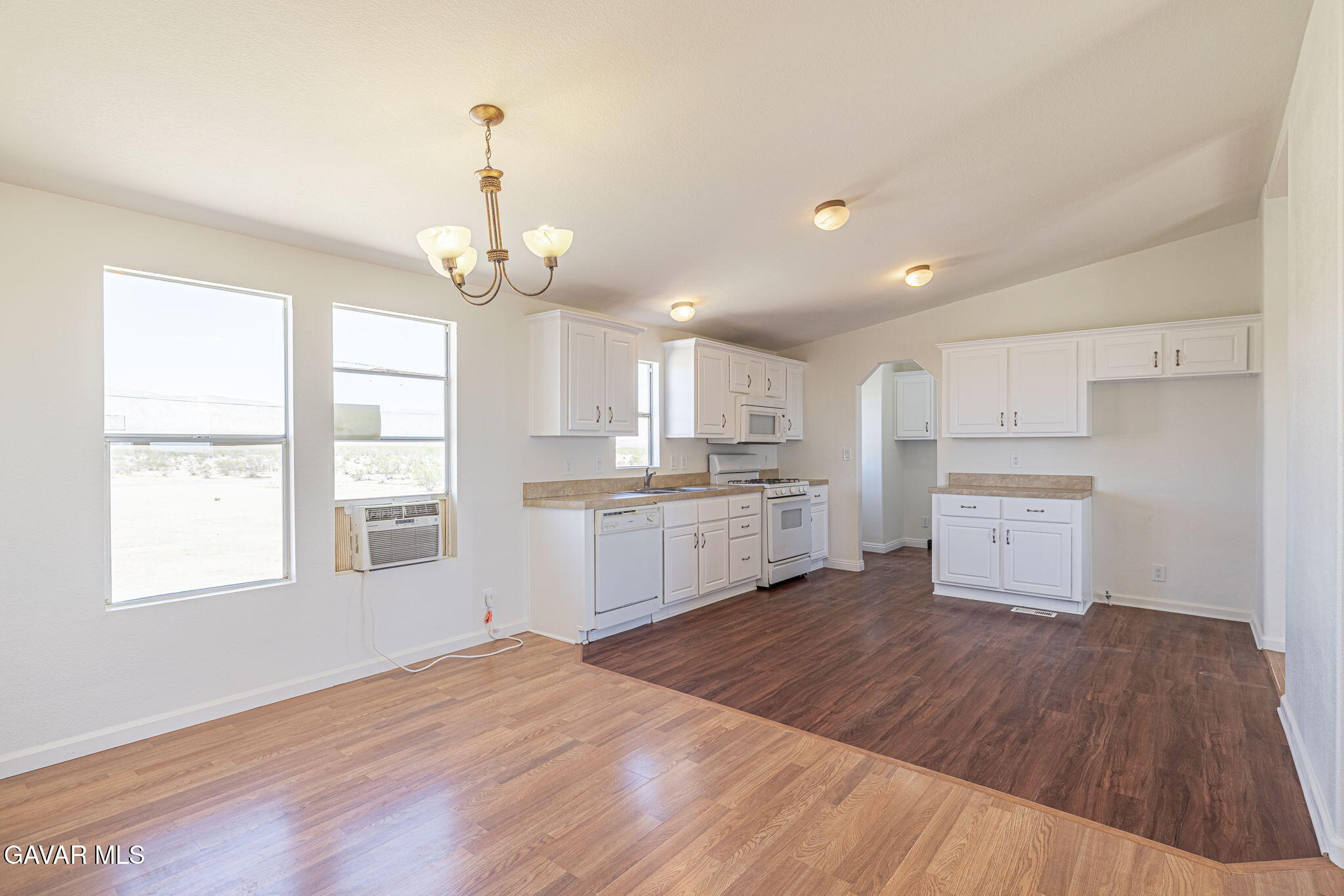 26321 Olanche Street Mojave, CA 93501 - Photo 10 of 40 a large kitchen with kitchen island a white cabinets and wooden floor