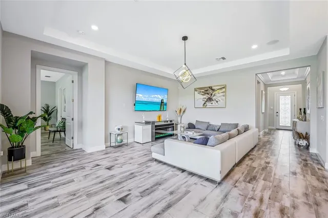 a living room with furniture or chandelier and a wooden floor