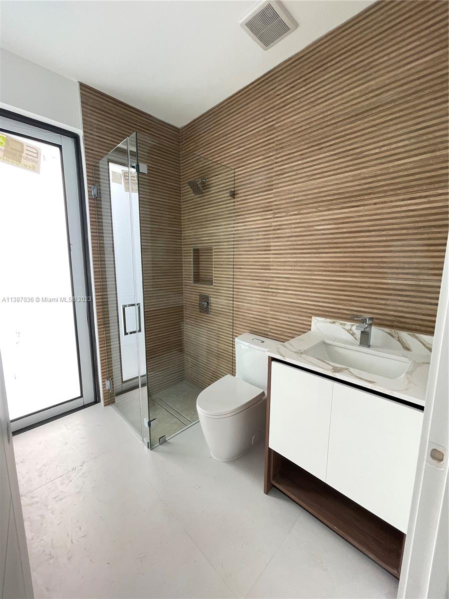 6535 Southwest 26th Street Miami, FL 33155 - Photo 7 of 19 a bathroom with a granite countertop toilet sink and mirror