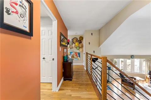 a view of a hallway with wooden floor and staircase