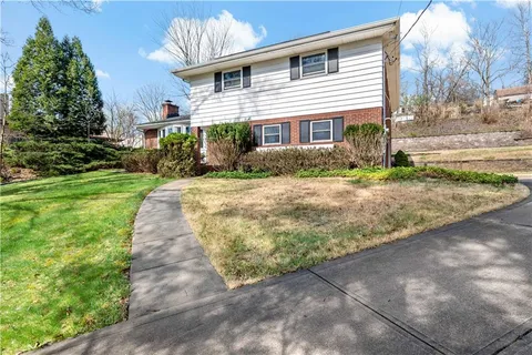 a front view of a house with a yard and potted plants
