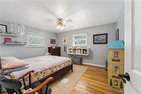 a spacious bedroom with a bed a dresser and a window