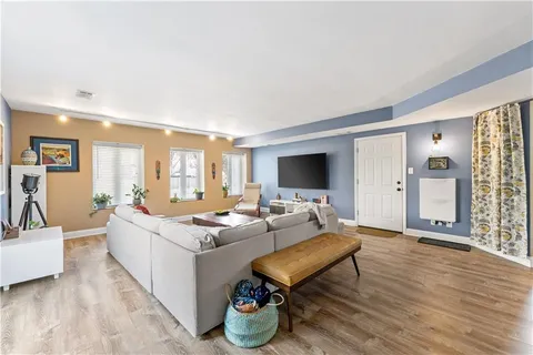 a living room with furniture a flat screen tv and a table