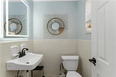 a bathroom with a toilet a sink and a mirror