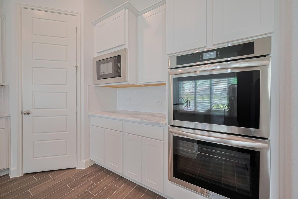 1051 Comal Trail Dayton, TX 77535 - Photo 12 of 49 a kitchen with white cabinets and stainless steel appliances