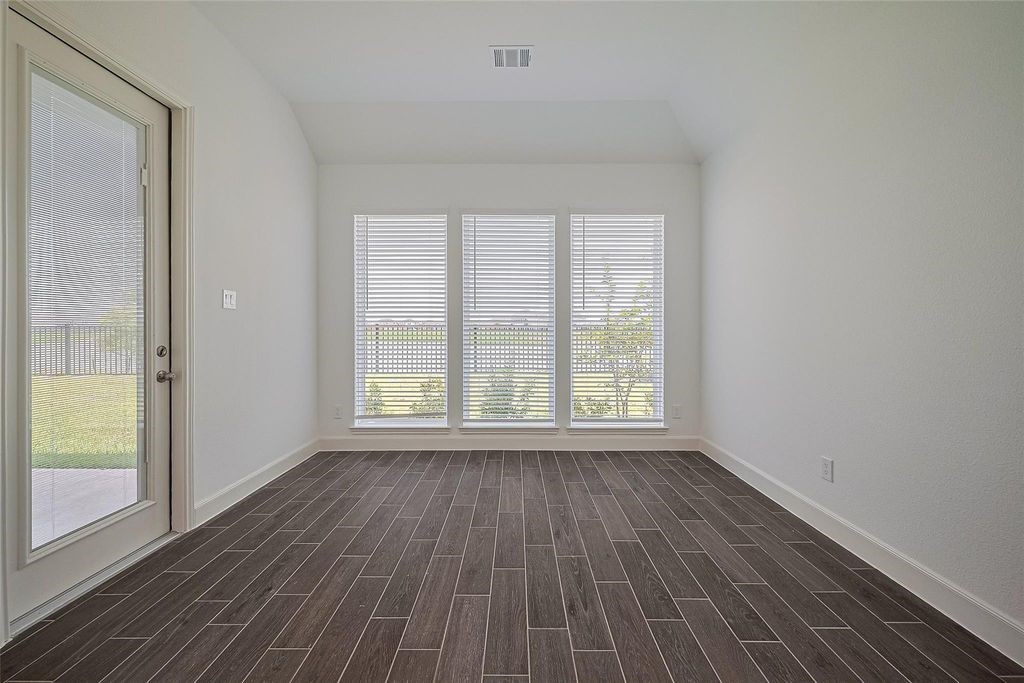 1051 Comal Trail Dayton, TX 77535 - Photo 15 of 49 a view of an empty room with wooden floor and a window