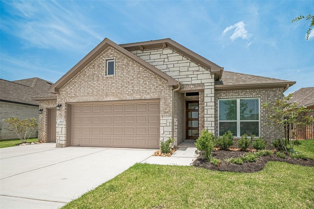 1051 Comal Trail Dayton, TX 77535 - Photo 2 of 49 a front view of a house with a yard and garage