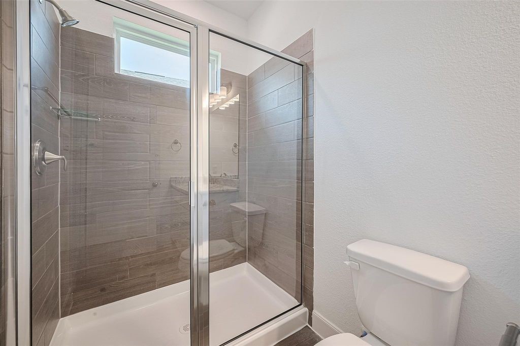 1051 Comal Trail Dayton, TX 77535 - Photo 25 of 49 a bathroom with a shower and toilet