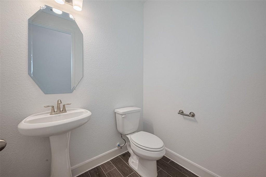 1051 Comal Trail Dayton, TX 77535 - Photo 31 of 49 a bathroom with a toilet sink and mirror
