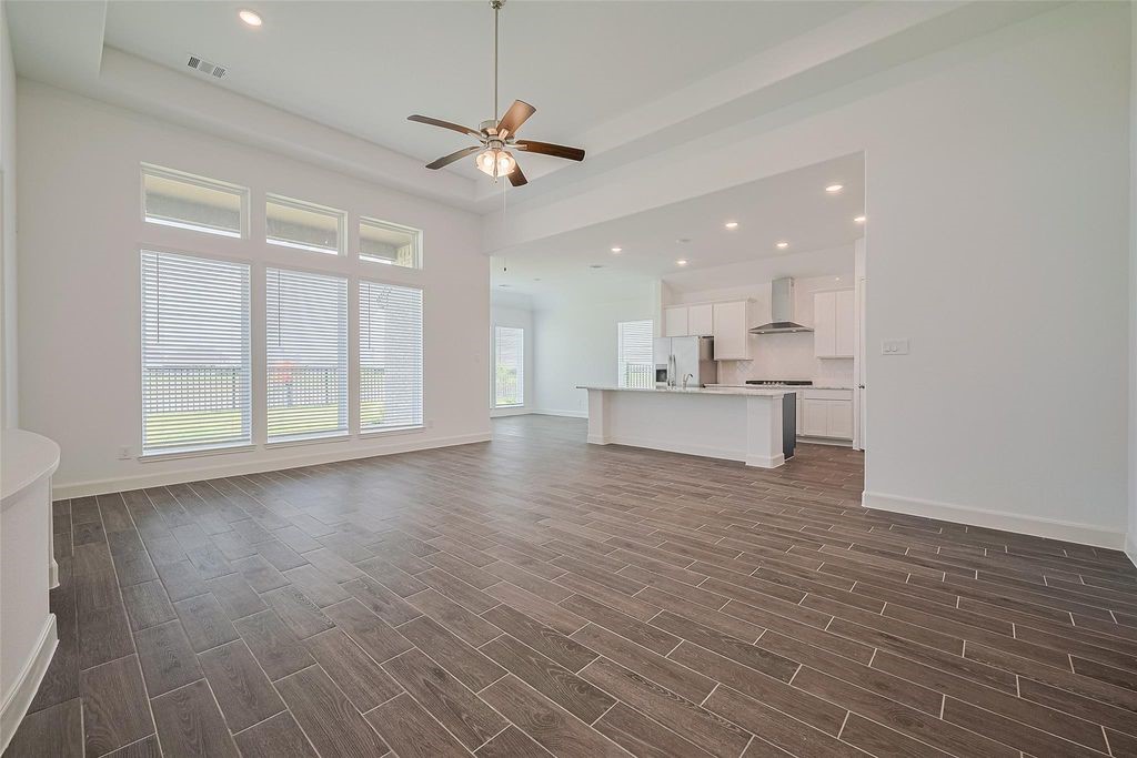 1051 Comal Trail Dayton, TX 77535 - Photo 6 of 49 a view of an empty room with wooden floor and a window