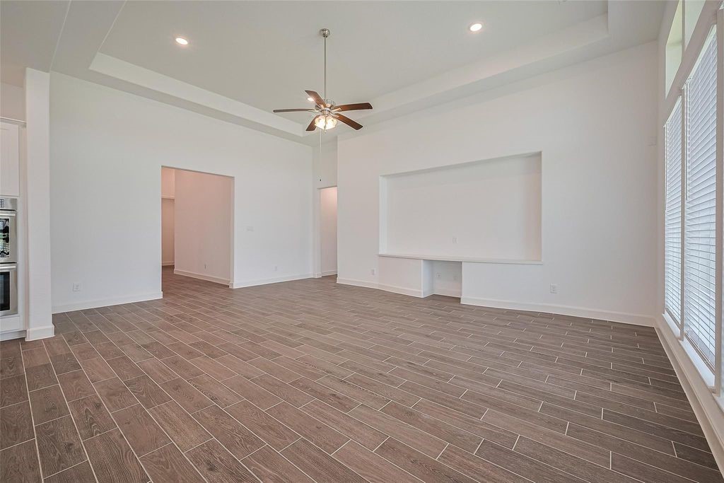 1051 Comal Trail Dayton, TX 77535 - Photo 7 of 49 a view of empty room with wooden floor and ceiling fan