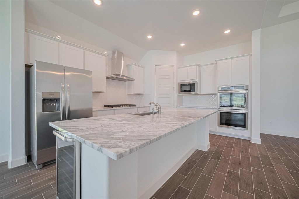 1051 Comal Trail Dayton, TX 77535 - Photo 10 of 49 a large kitchen with kitchen island a sink stainless steel appliances and cabinets