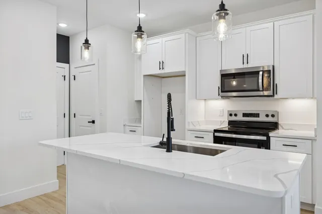 a kitchen with stainless steel appliances a stove a sink and a refrigerator