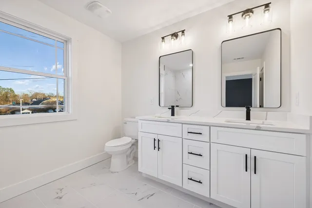 a bathroom with a double vanity sink and a mirror