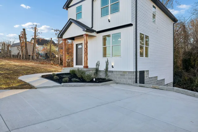 a front view of a house with a yard and potted plants