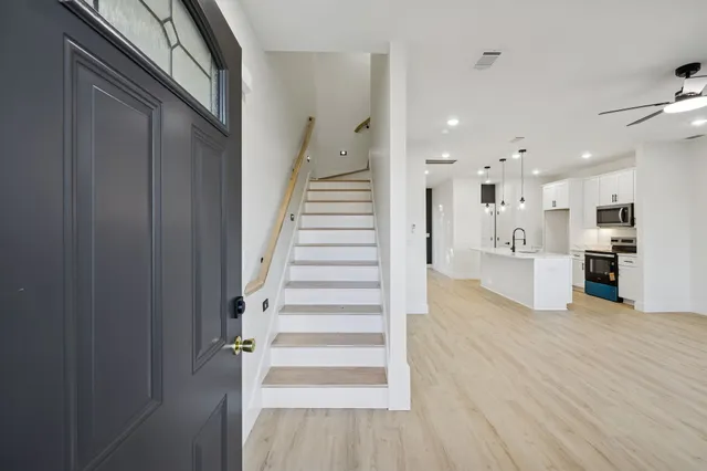 a view of a kitchen with wooden floor and stairs