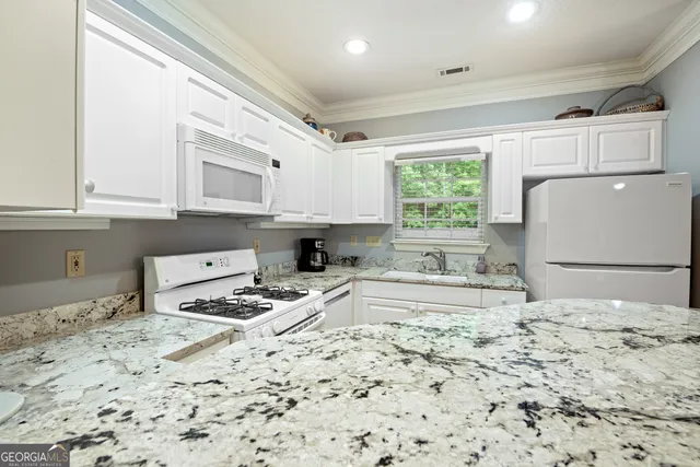 a kitchen with a stove a refrigerator and cabinets