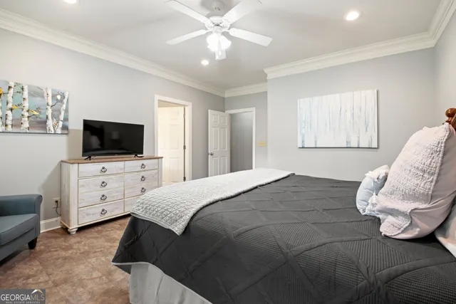 a bedroom with a bed television on dresser and a flat screen tv