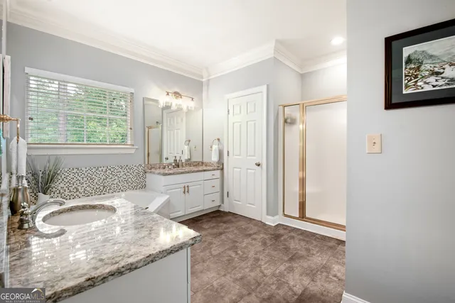 a bathroom with a granite countertop sink mirror vanity and a bathtub