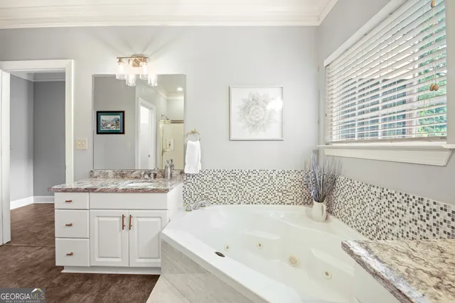 a bathroom with a bathtub a sink a window and a mirror