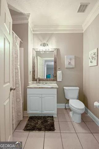 a bathroom with a granite countertop sink a toilet a mirror and shower