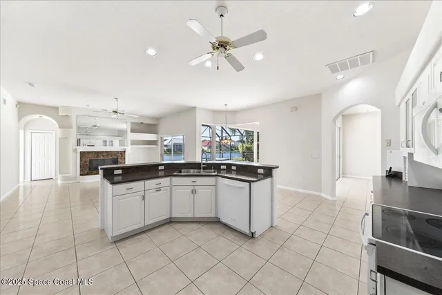 a kitchen with granite countertop a sink and white cabinets