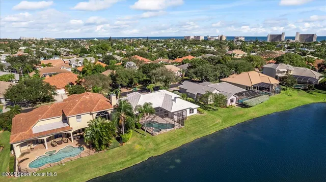 an aerial view of residential houses with outdoor space and a lake view