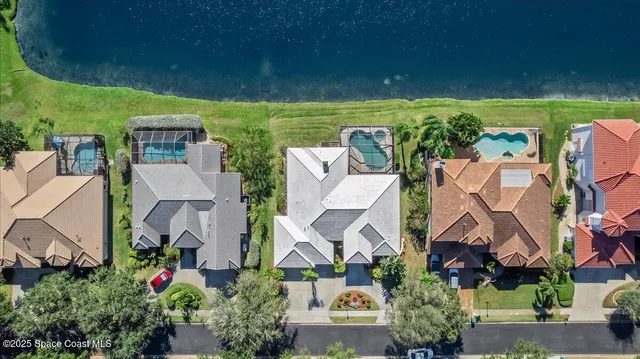 an aerial view of a house with a garden and lake view