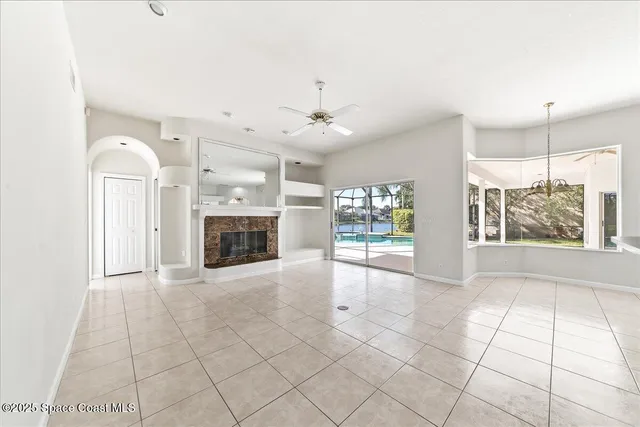 a view of an empty room with a fireplace and a window