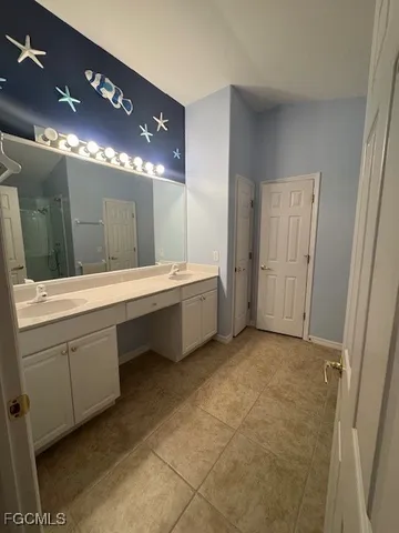 a bathroom with a double vanity sink a large mirror and a shower