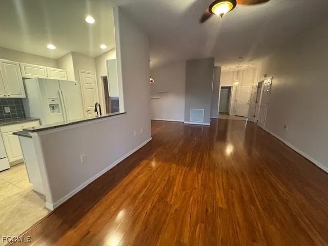 a view of a kitchen with wooden floor and a sink