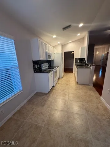 a large kitchen with a large counter top stainless steel appliances and cabinets