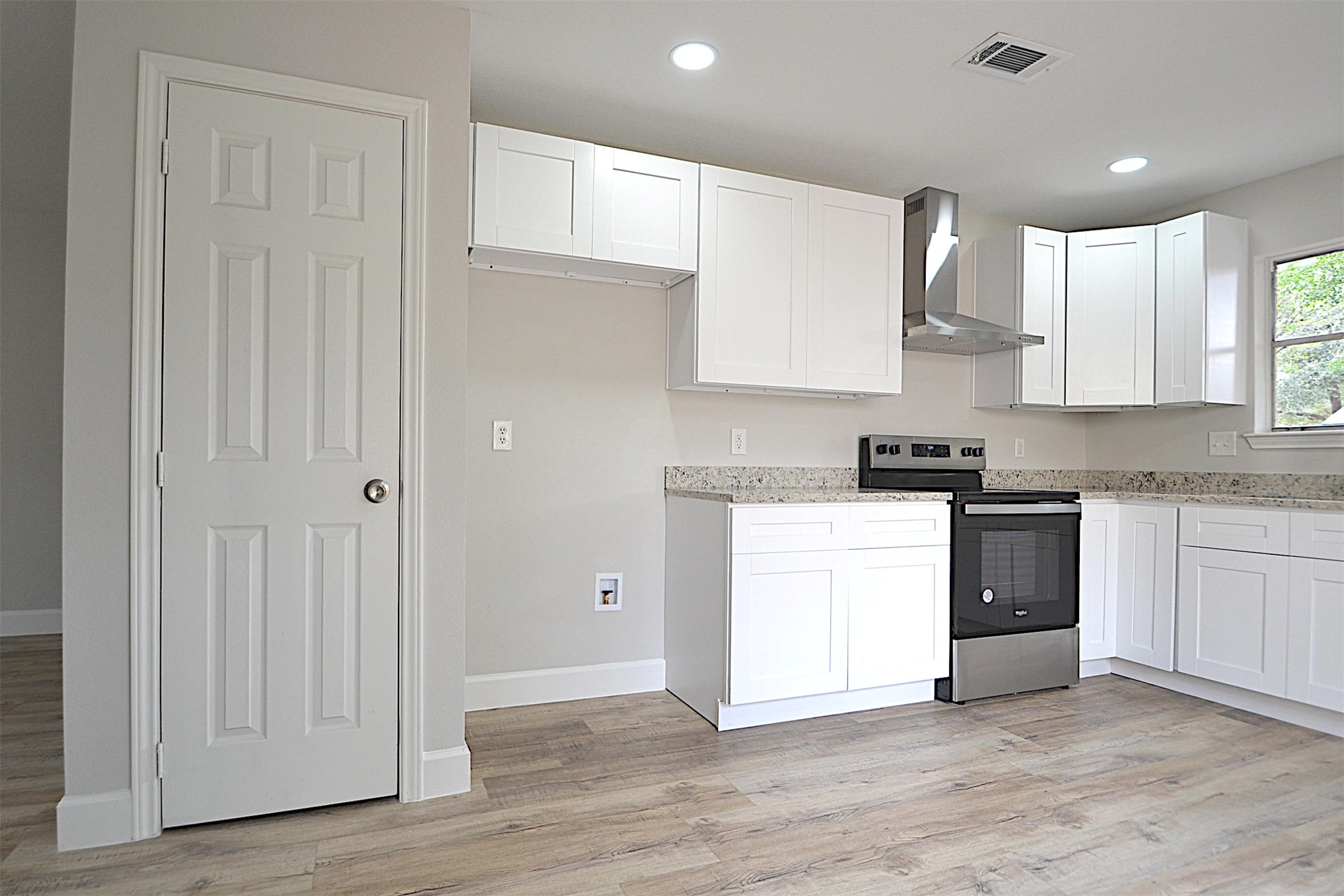 a kitchen with granite countertop white cabinets and white appliances