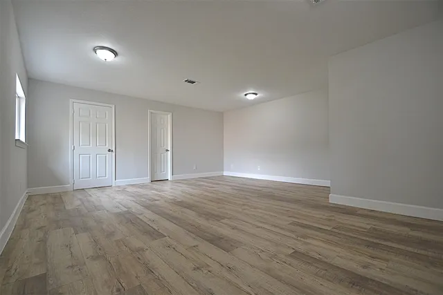 a view of an empty room with wooden floor