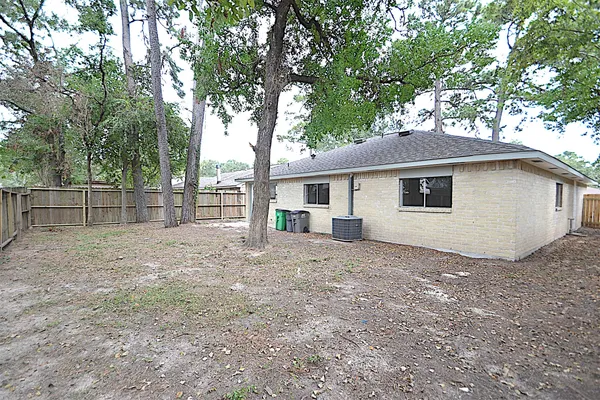 a view of a house with a yard and large tree