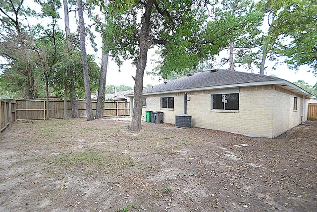 a view of a house with a yard and large tree