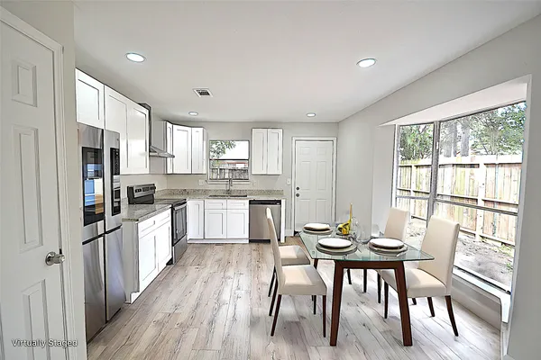 a kitchen with a table chairs refrigerator and cabinets