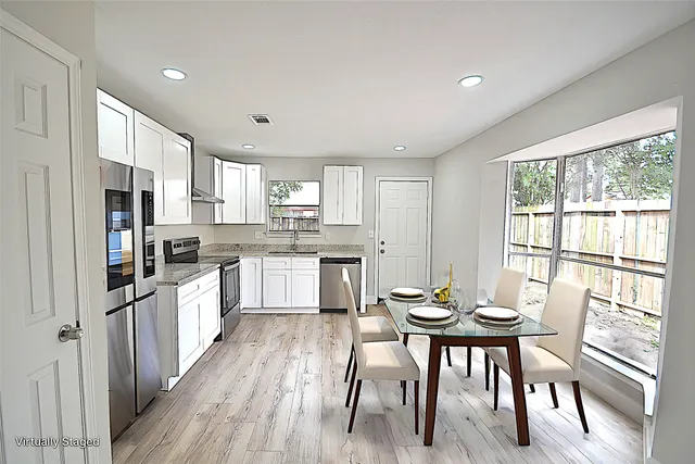 a kitchen with a table chairs refrigerator and cabinets