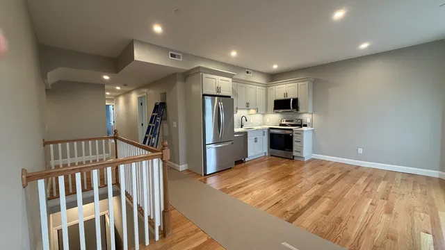 a view of a kitchen with a sink and stainless steel appliances