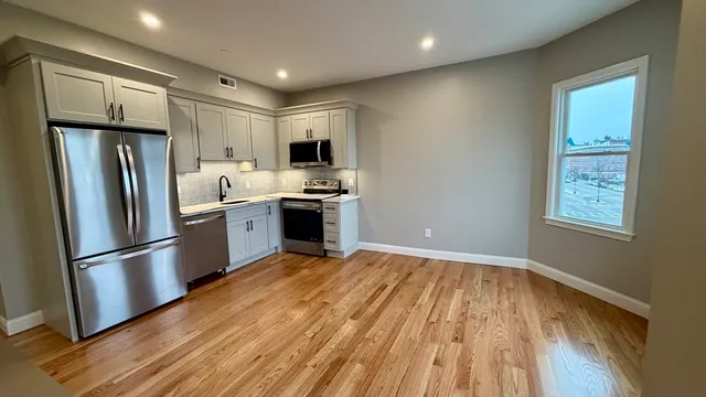 a kitchen with stainless steel appliances granite countertop a refrigerator sink and microwave